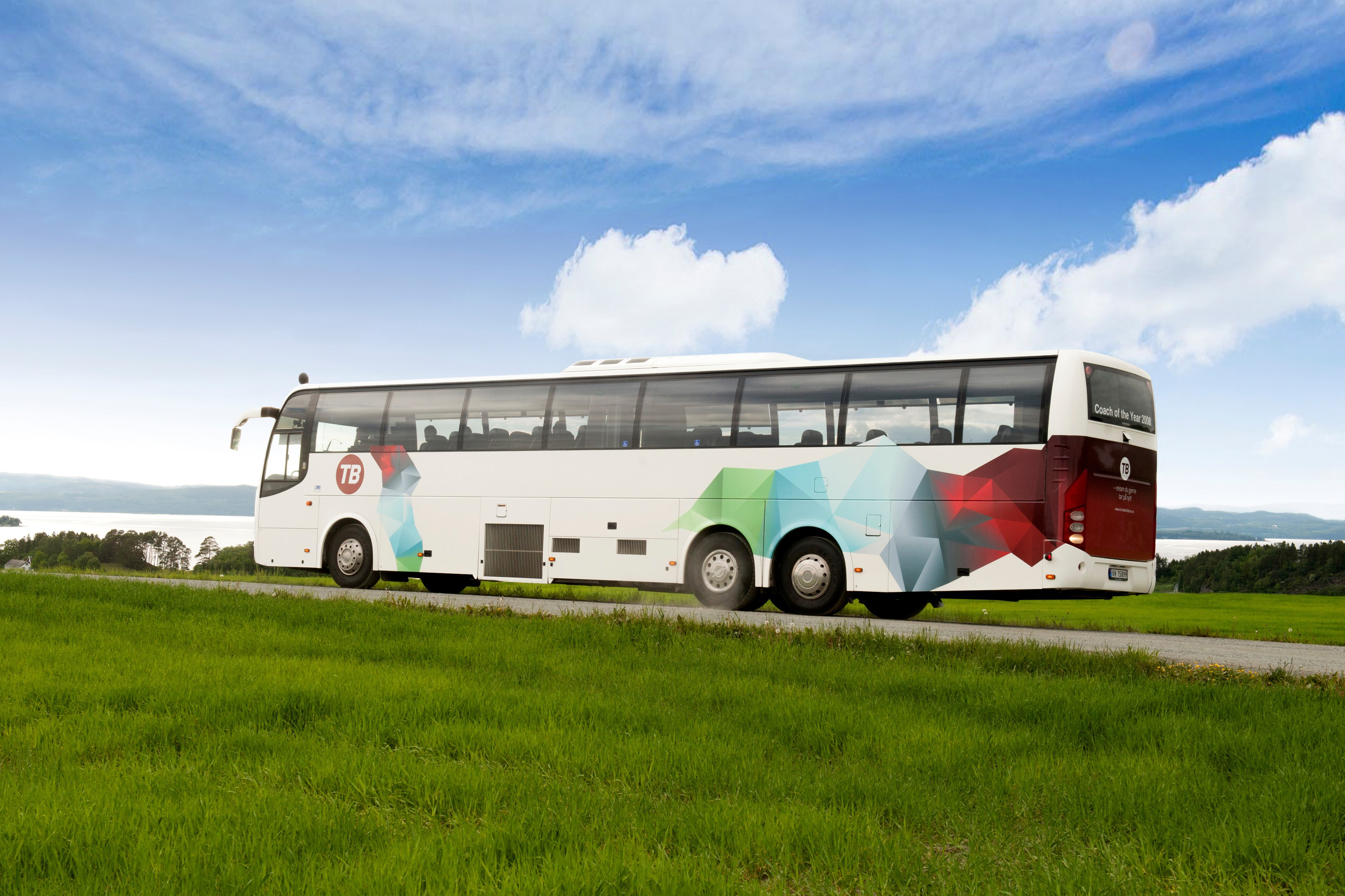 Torghatten-Bus zwischen Wiesen am Wasser